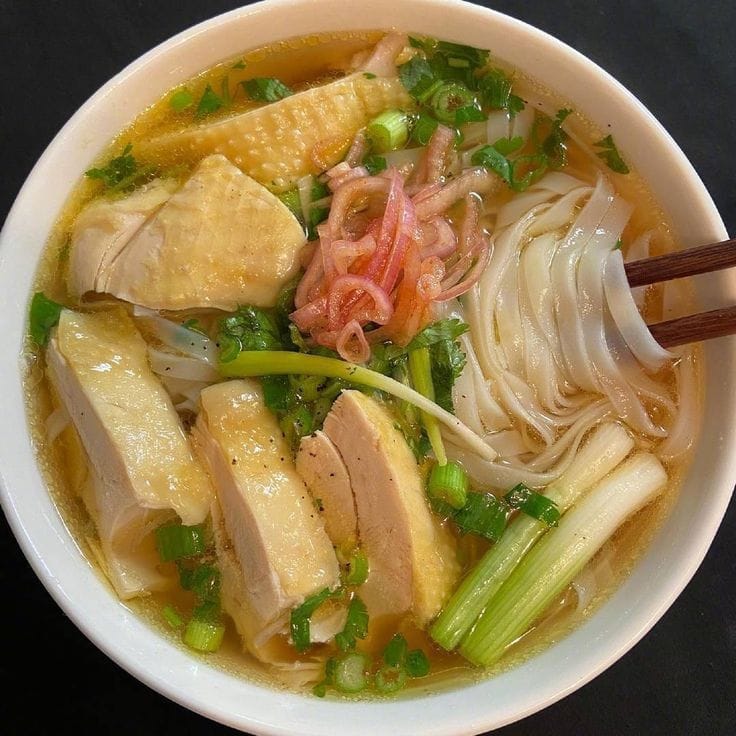 tender-chicken-in-golden-broth-silky-rice-noodles-pickled-red-onions-a-touch-of-cilantro-and-fresh-scallions
